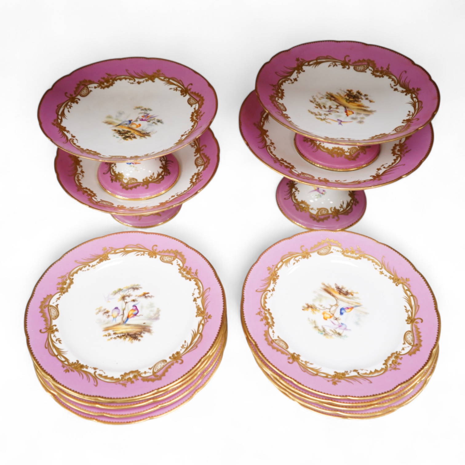 A Minton pink ground dessert service, in Sevres style, c.1850, hand painted with birds, comprising four comports and ten dessert plates, 23cm in diameter